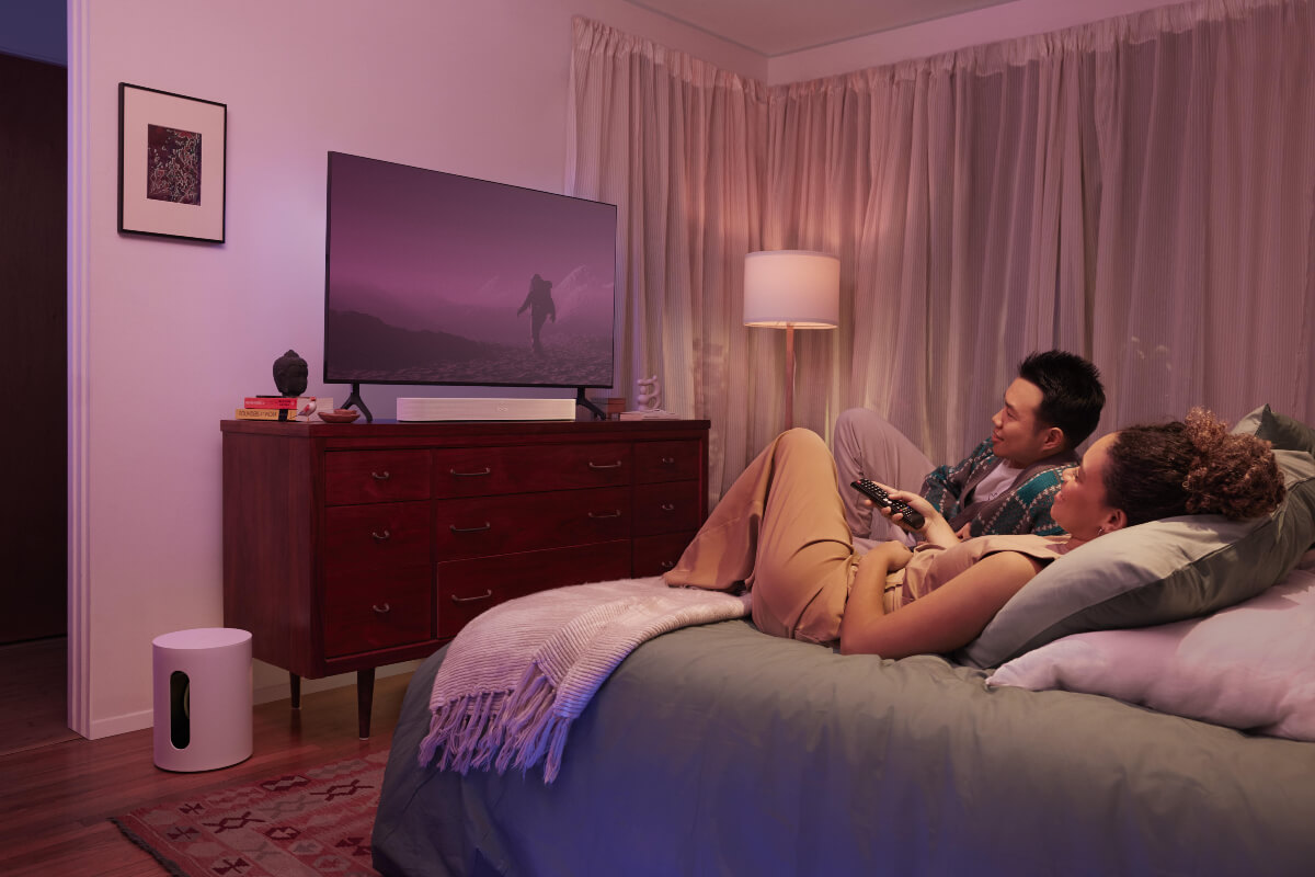 Una pareja viendo contenido multimedia con el Sub Mini de Sonos.