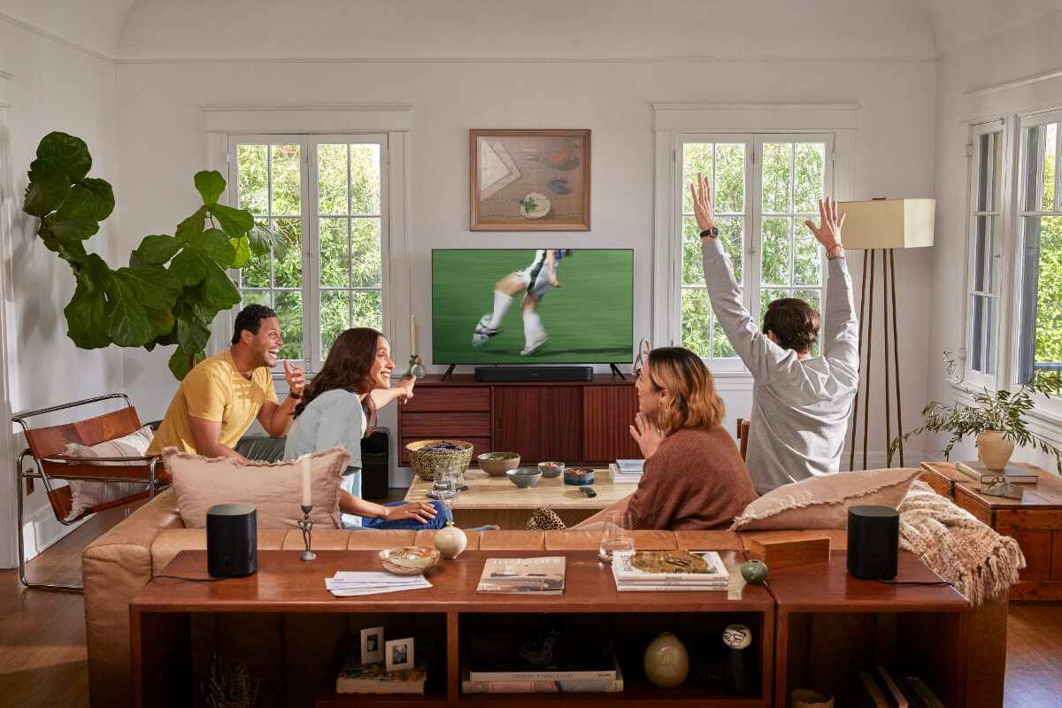 Un grupo de personas viendo un partido de fútbol con una barra de sonido Sonos.