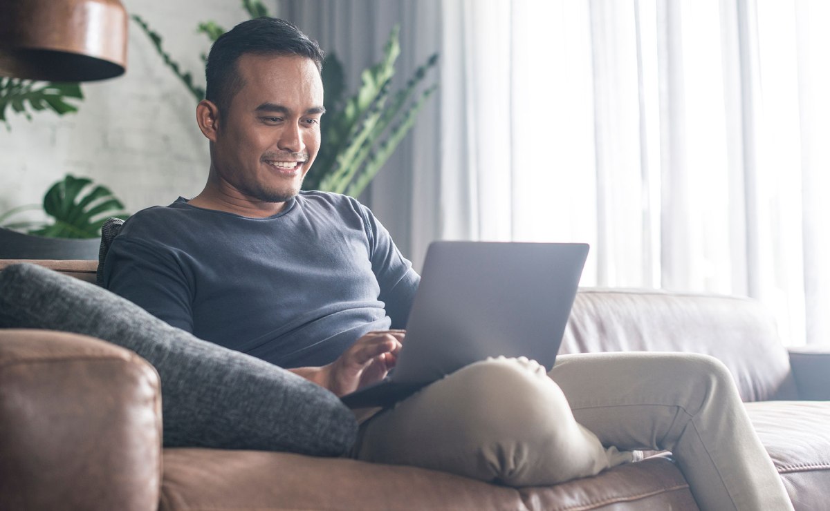 Un hombre revisa su computadora portátil.