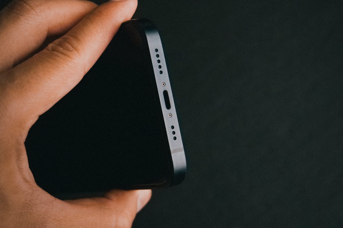 Persona muestra el puerto de carga de un celular.
