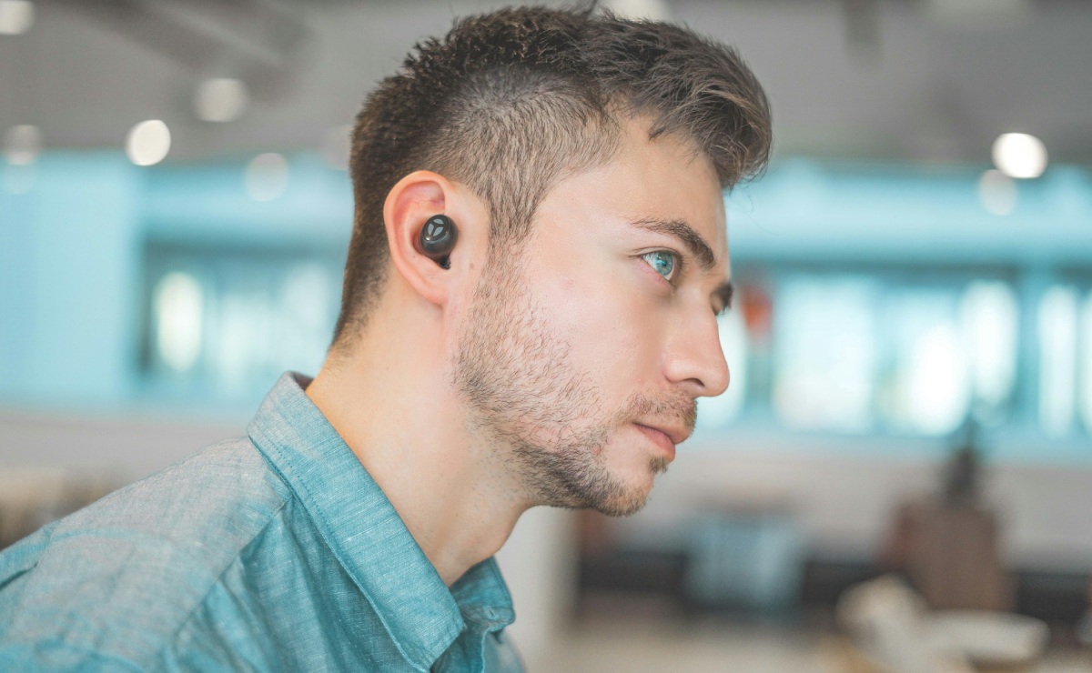 Joven está escuchando música en el exterior.